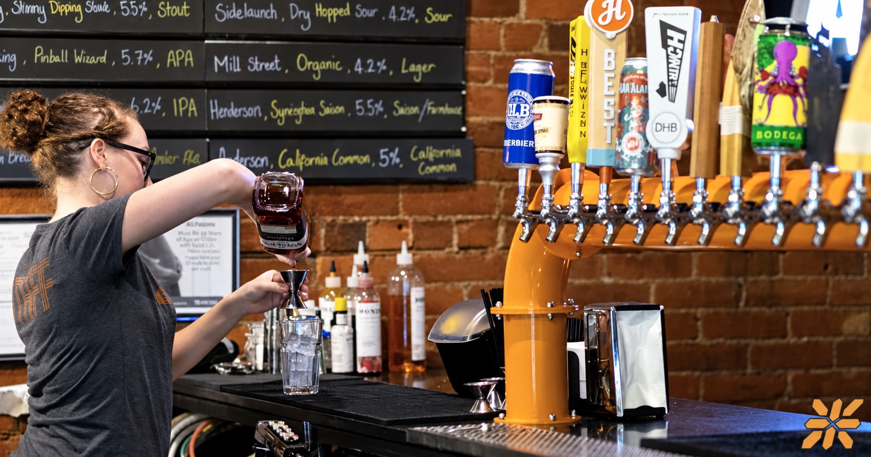 A ZED*80 bartender preparing a drink beside the orange tap tower